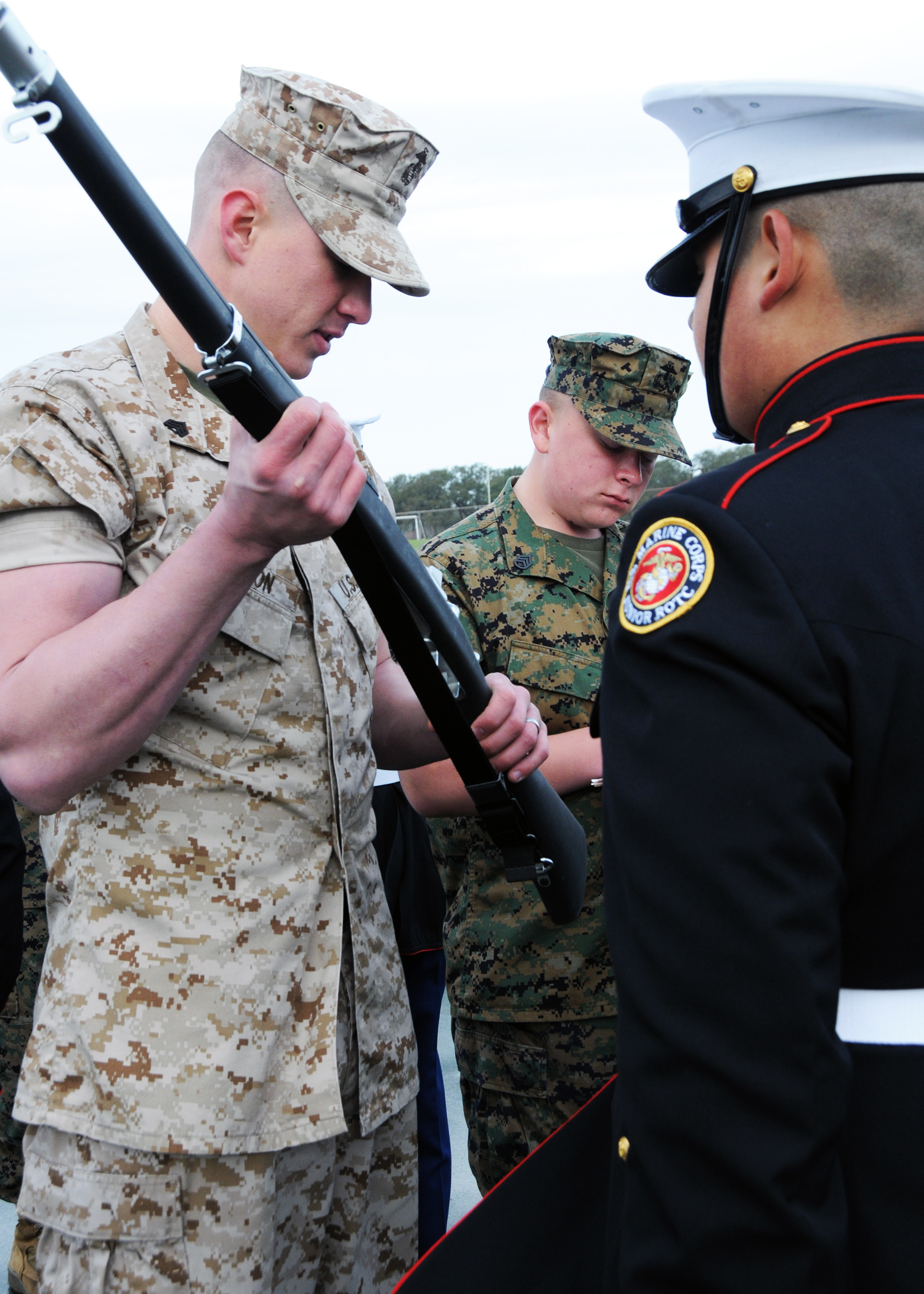 Sgt. Joshua Shannon, left, a recruiter from Marine Corps Recruiting Station San Antonio, Recruiting Sub-Station Austin South, inspects the rifle of a Marine Corps Junior Reserve Officer Training Corps cadet from W.T. White High School at an all-Marine JROTC competition at Jack C. Hays High School, in Buda, Texas, March 5, 2011.